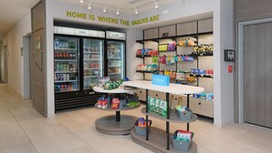 A hotel snack area with a self-service kiosk, refrigerated drinks, and a variety of snacks and beverages. - Home2 Suites By Hilton Lima (Lima)