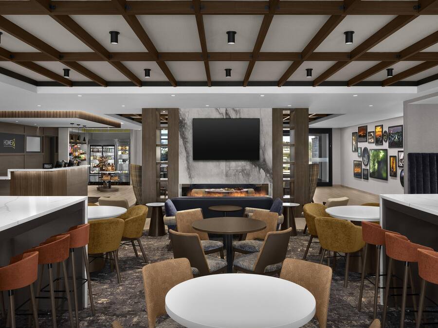 A modern lounge area with a fireplace, bar, and seating.