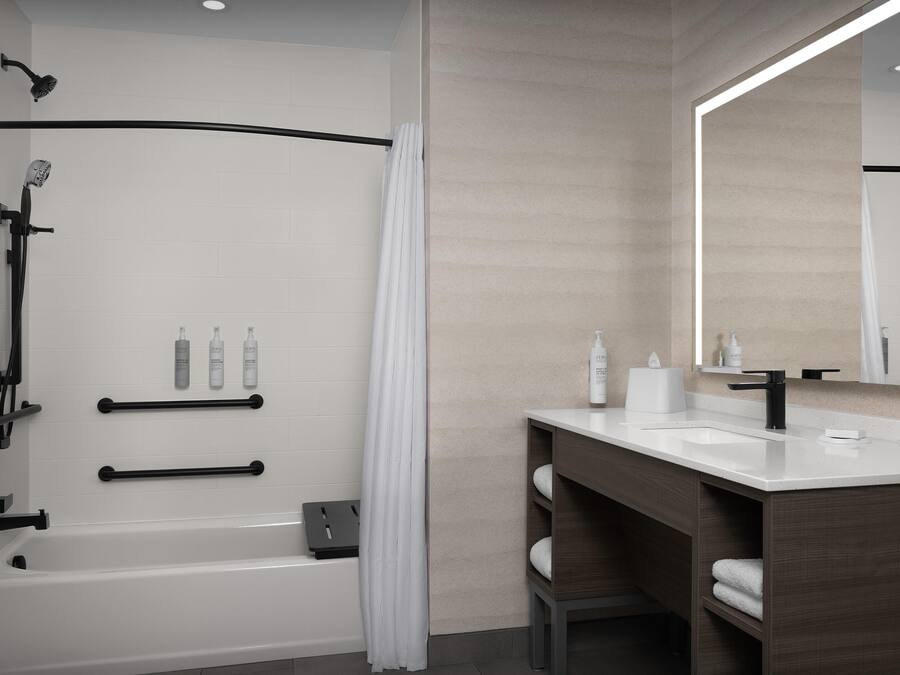 Une salle de bain moderne équipée d’une baignoire, d’une douche et d’un meuble-lavabo avec un miroir.