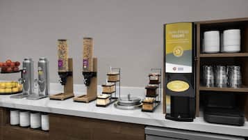 A breakfast bar with various food and drink dispensers, including yogurt, cereal, and coffee options.