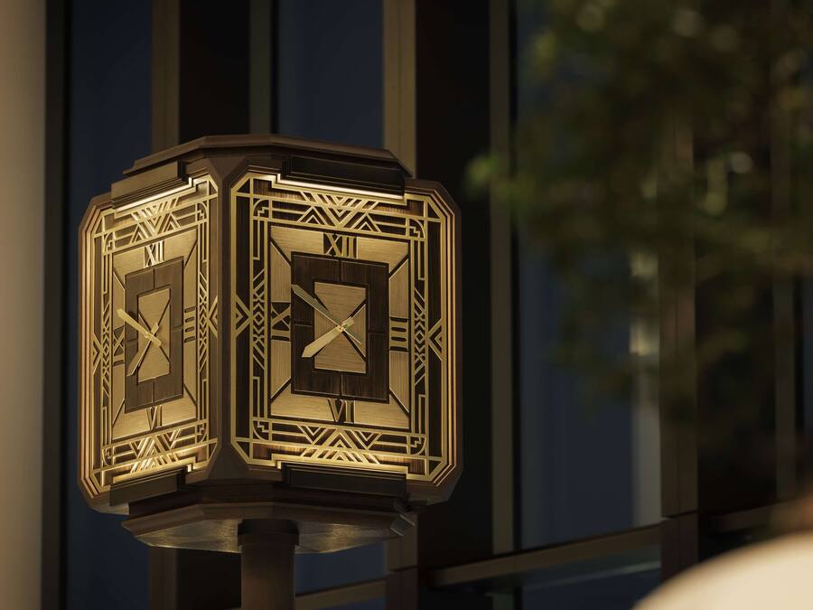 A decorative clock with Roman numerals and geometric patterns, mounted on a post.