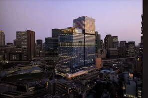 Ein Hochhaus mit Glasfassade, umgeben von weiteren Wolkenkratzern in einer Stadtansicht.