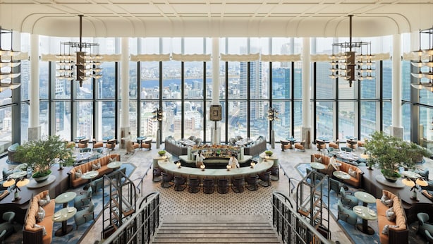 A spacious bar area with a city view, multiple seating arrangements, and a central bar counter. - Waldorf Astoria Osaka (Osaka)