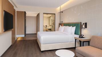 Ein Hotelzimmer mit einem Bett, einem Nachttisch mit Telefon, einem kleinen runden Tisch und einem Sofa.