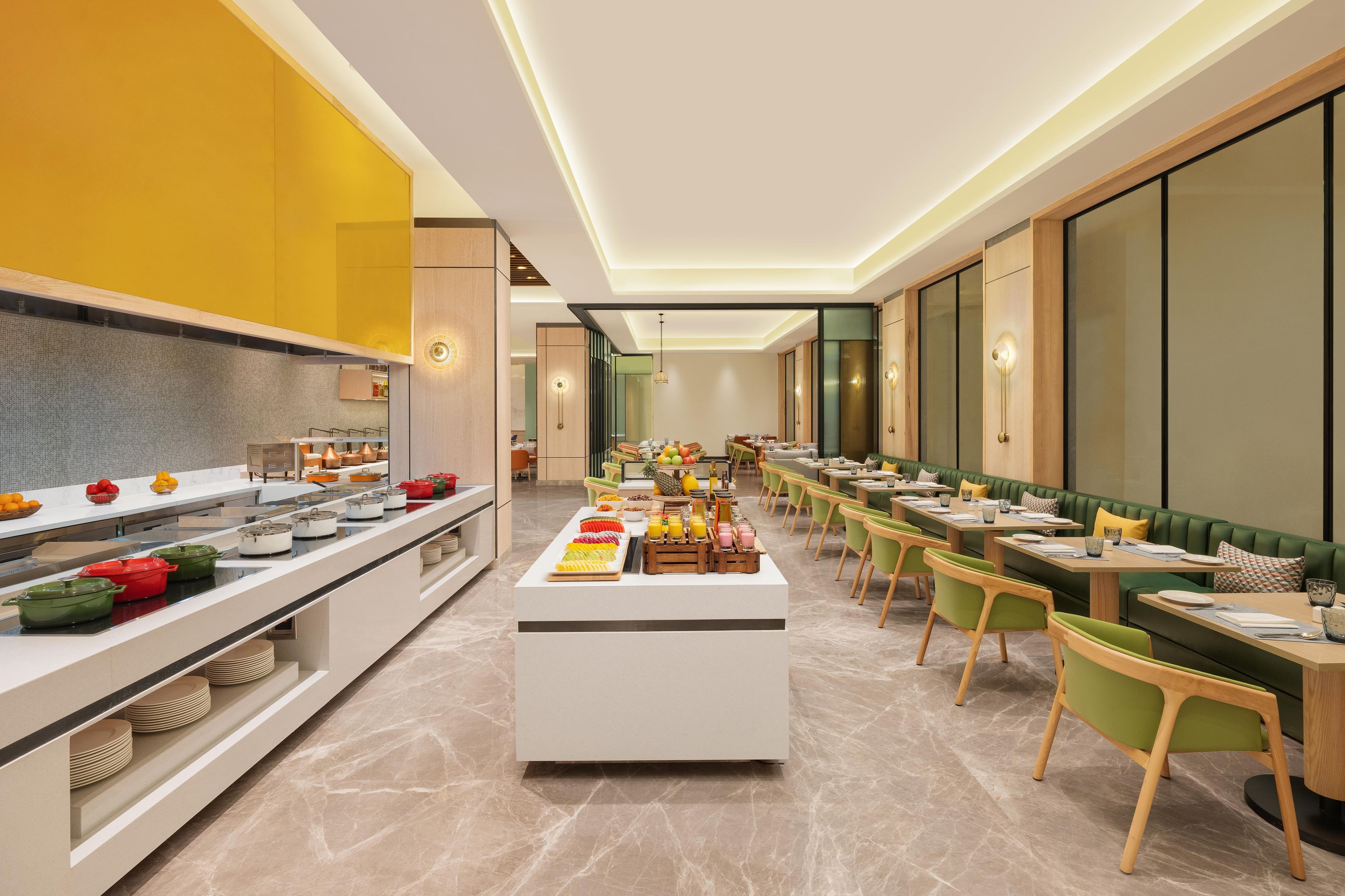 A modern dining area with a buffet setup, seating arrangements, and a central serving station.