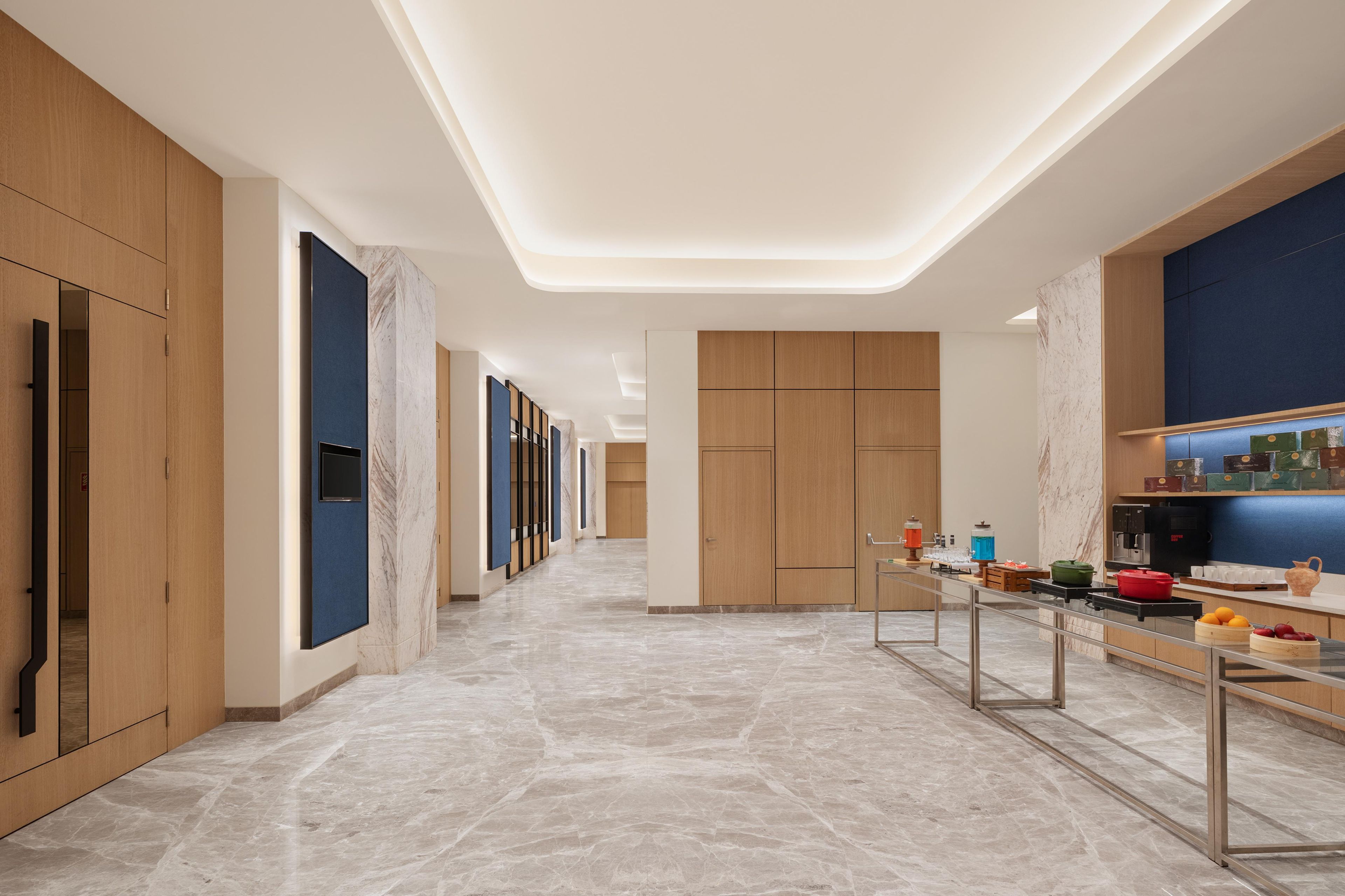 Cocina moderna con pisos de mármol, gabinetes de madera y una isla central con pileta y encimera.