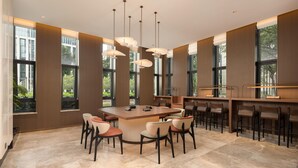 Una cocina moderna con una isla central, asientos tipo barra y ventanas amplias.