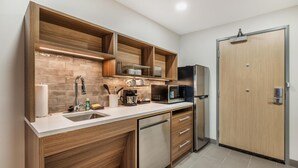 Une cuisine moderne avec des meubles en bois, un four à micro-ondes encastré et un lave-vaisselle.