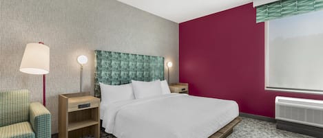 A hotel room with a bed, nightstands, a lamp, a chair, and a window.