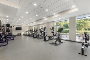 Een fitnessruimte met loopbanden, elliptische trainers en gewichthefapparatuur.