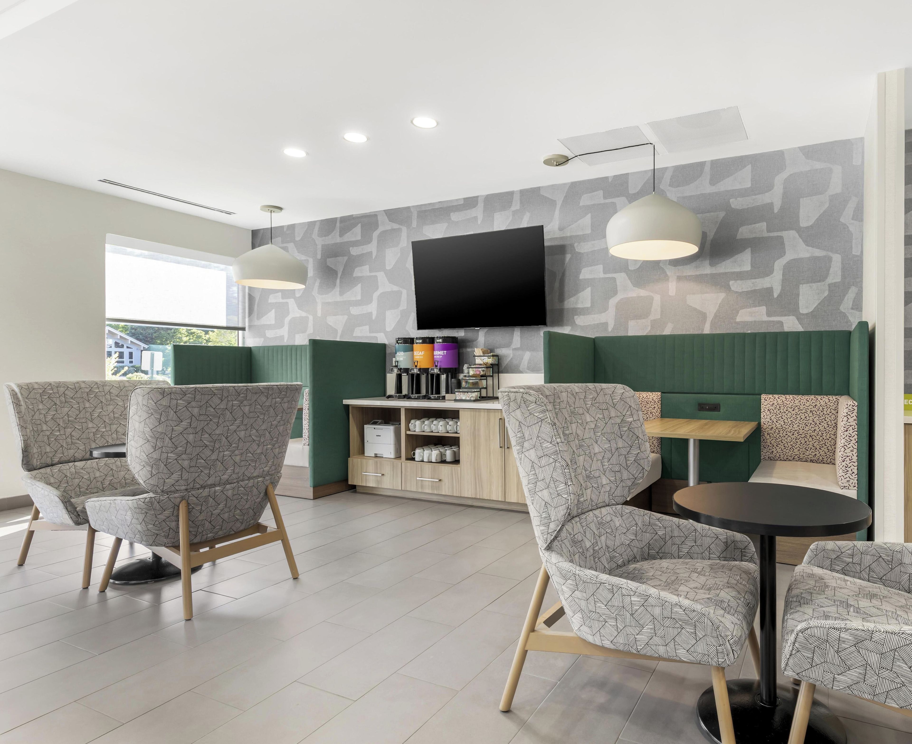 Un interior moderno con asientos, un televisor de pantalla plana y una zona de café.