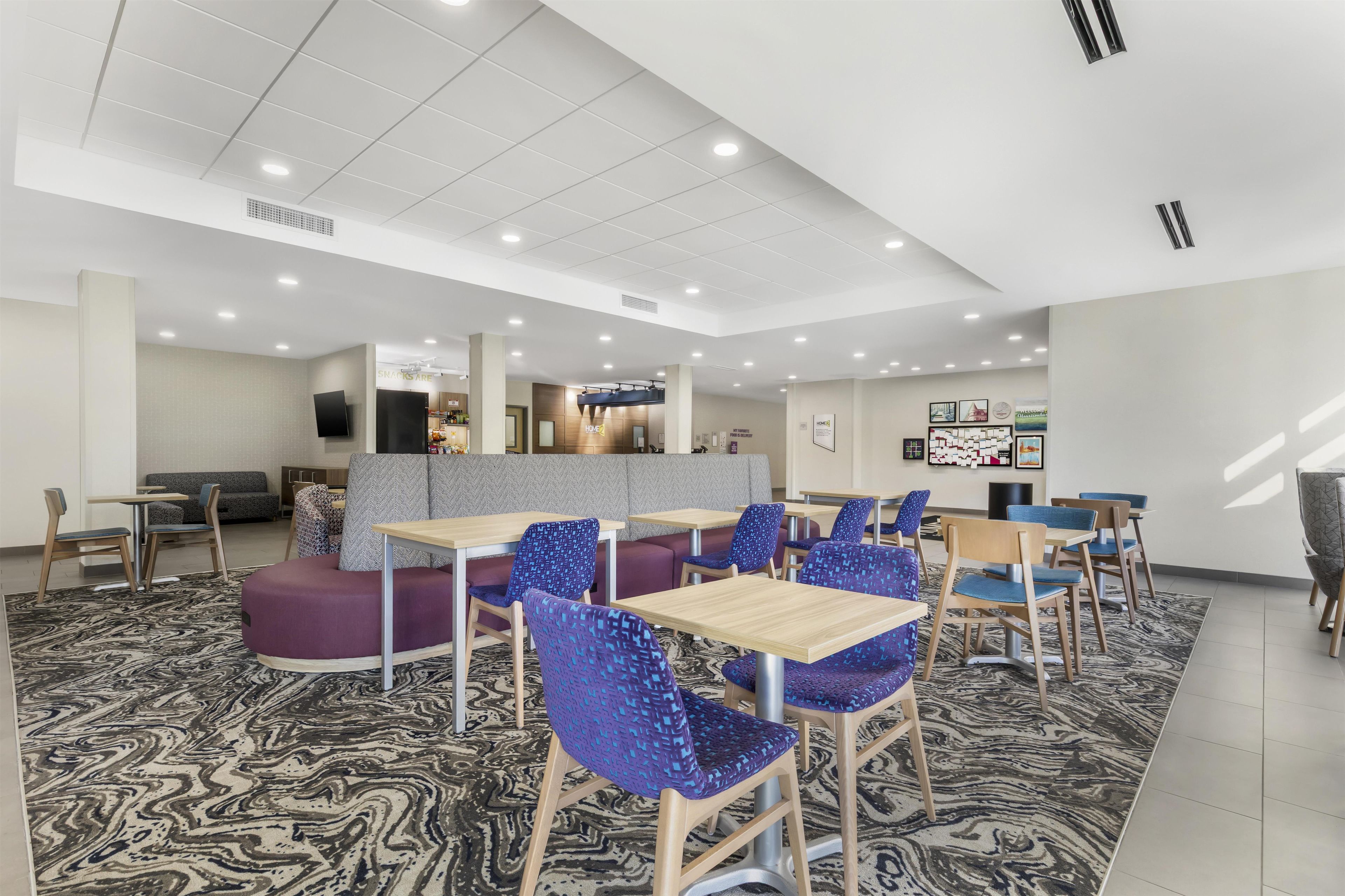 A modern indoor space with seating areas, tables, and a counter.