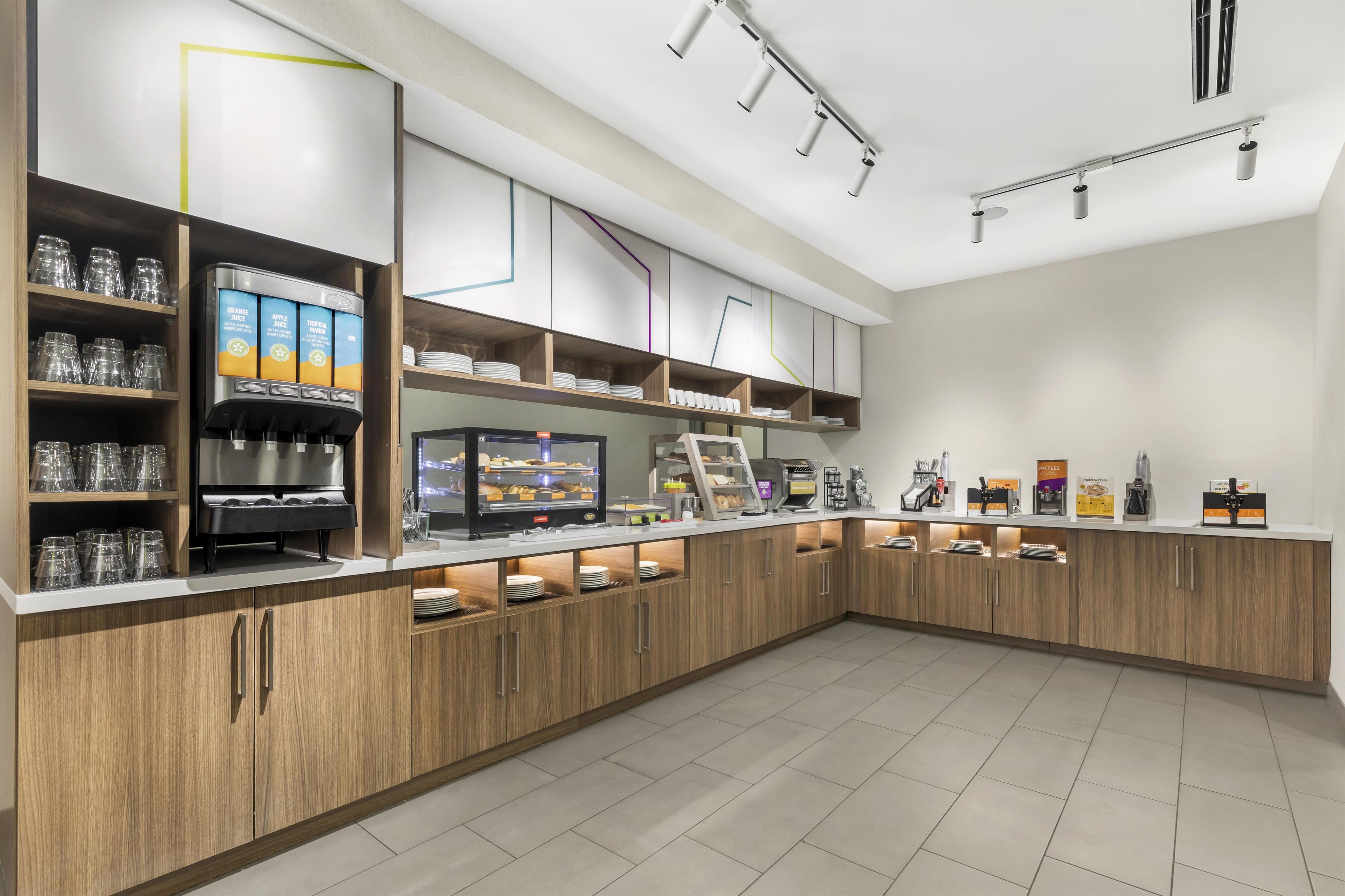 Een modern café met een bedieningsluik, koffieautomaten en diverse eetgelegenheden.