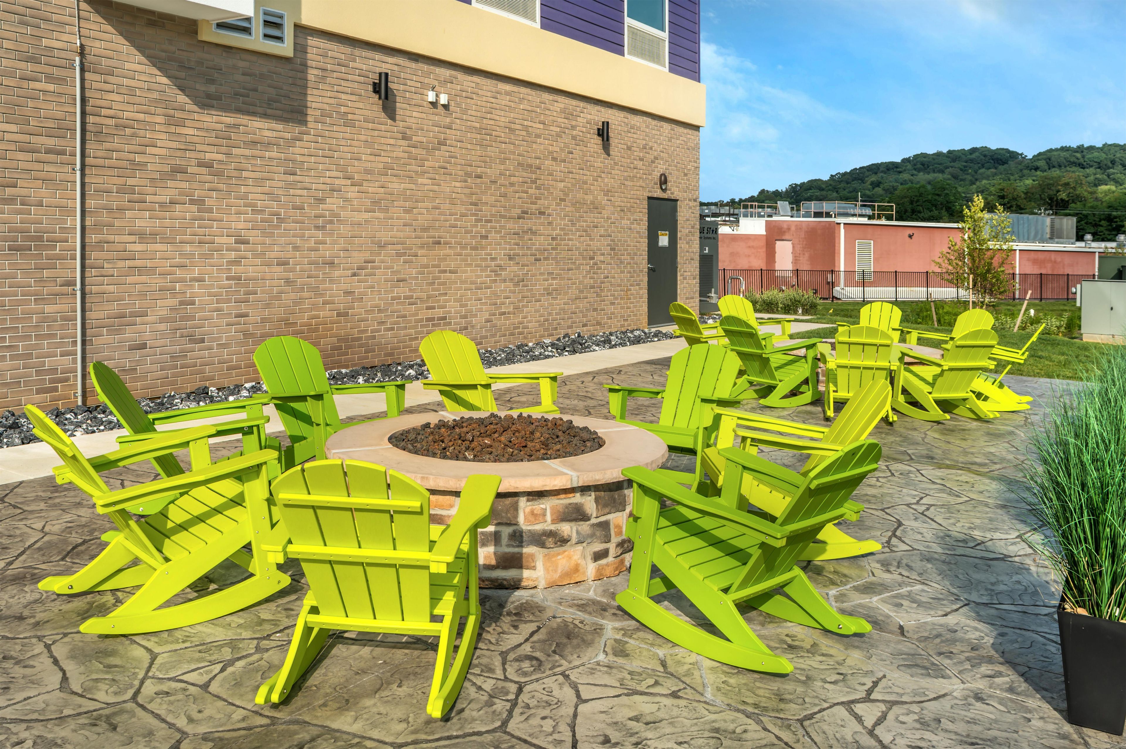 A patio with Adirondack chairs and a fire pit.