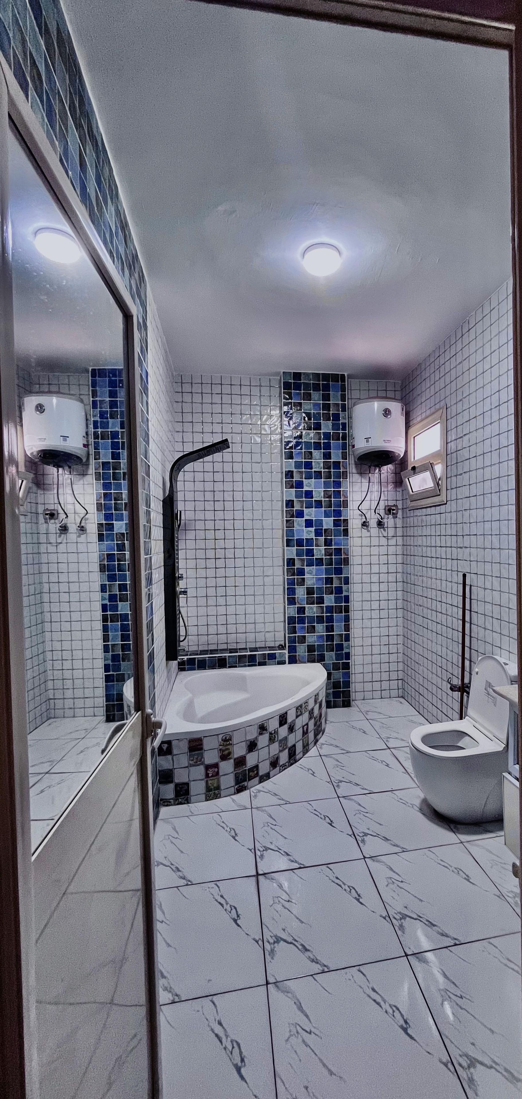 Ein Badezimmer mit Badewanne, Toilette und Duschbereich.