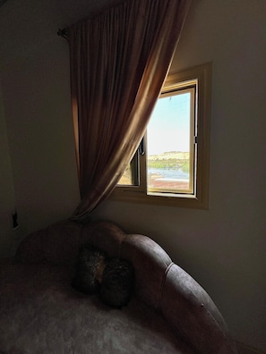A room with a bed, a window with curtains, and a view of a landscape. - condo in beautiful Aswan Governorate with WiFi, AC (Aswan Governorate)