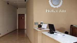 A reception desk at Hotel Jaú with a sign prohibiting animal entry, a computer, and some papers on the counter. - Hotel Jaú (Jau)