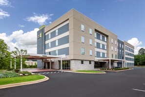 A multi-story hotel with a covered entrance and a parking lot.