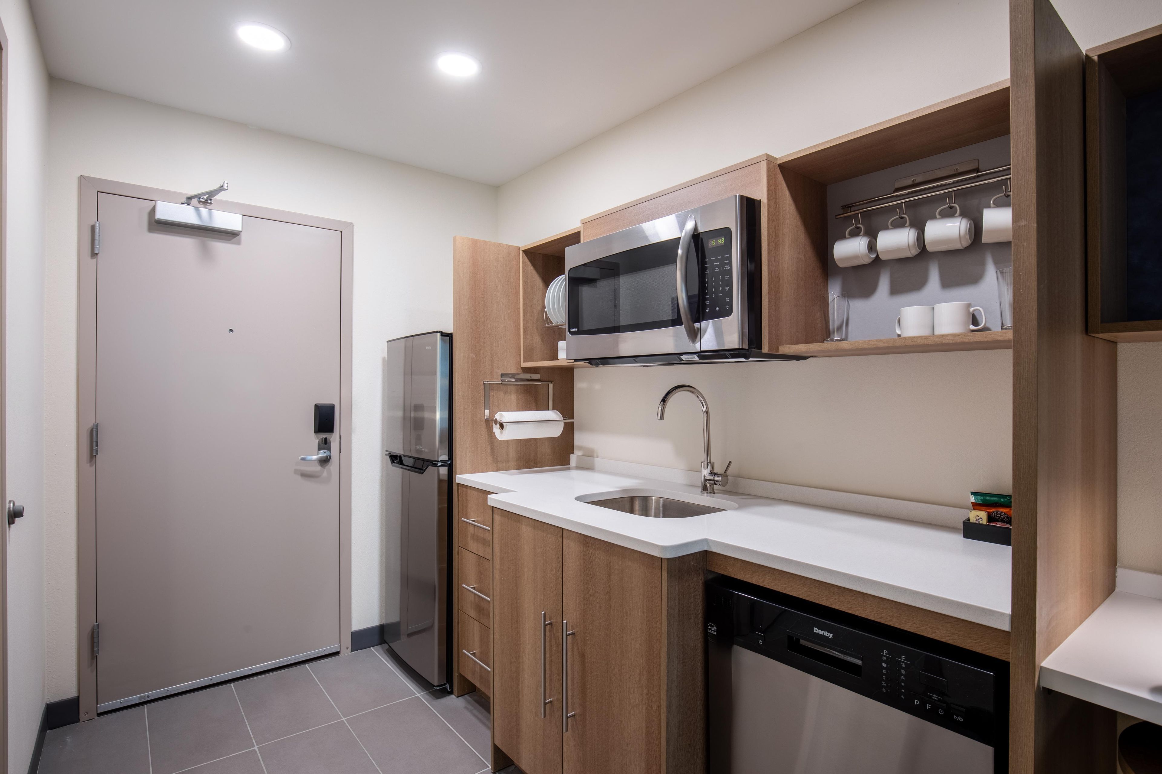 A compact kitchen with a microwave, refrigerator, and dishwasher.