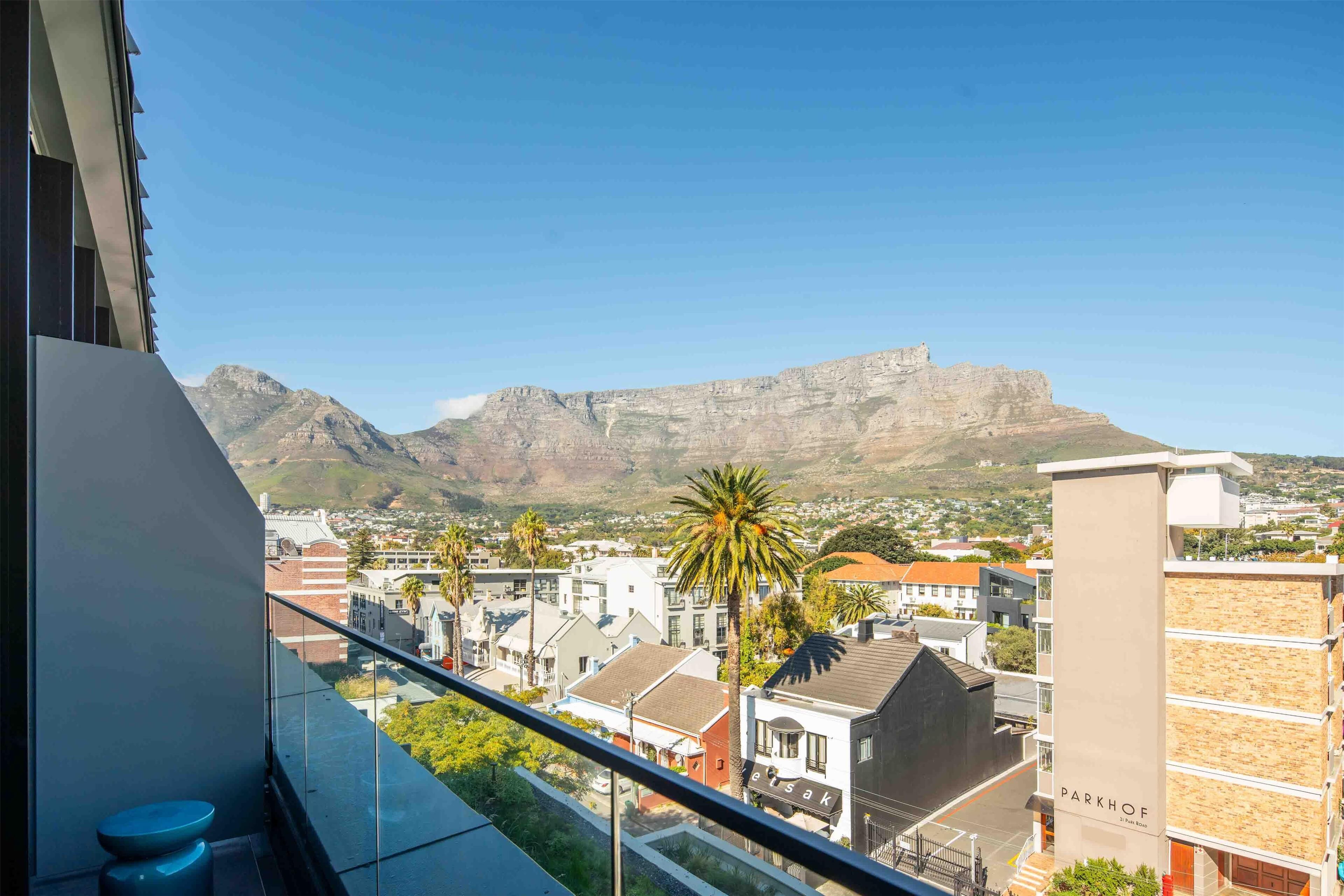 Un balcon offrant une vue sur une montagne et sur le paysage urbain.