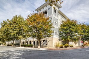 Un edificio de varios pisos con techo plano, una galería techada y un estacionamiento.