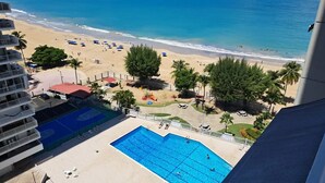 A hotel with a swimming pool, beach access, and a view of the ocean.