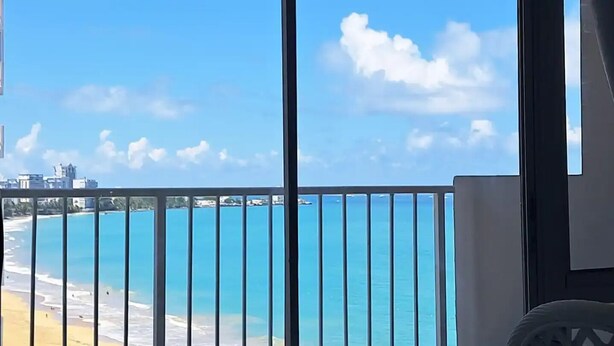 A balcony with a view of a beach and ocean.