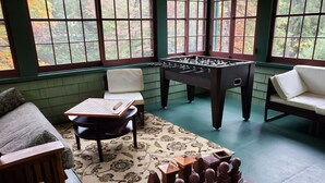 Una habitación con una mesa de fútbol de mesa, un tablero de ajedrez y un juego de damas.