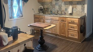 A kitchen with wooden cabinets, a granite countertop, and a hanging pot rack.
