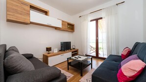 A modern living room with a sofa, a coffee table, a TV, and a wooden cabinet. - Awesome home in Murvica Gornja (Murvica Gornja)