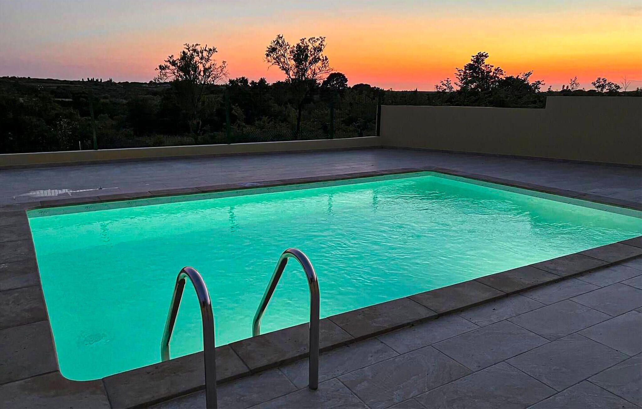 A rectangular pool with clear water, surrounded by a tiled deck.