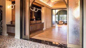 A spacious lobby with a marble floor, a reception desk, and a seating area with a view of the outdoors. - DELAMAR MYSTIC (Mystic)