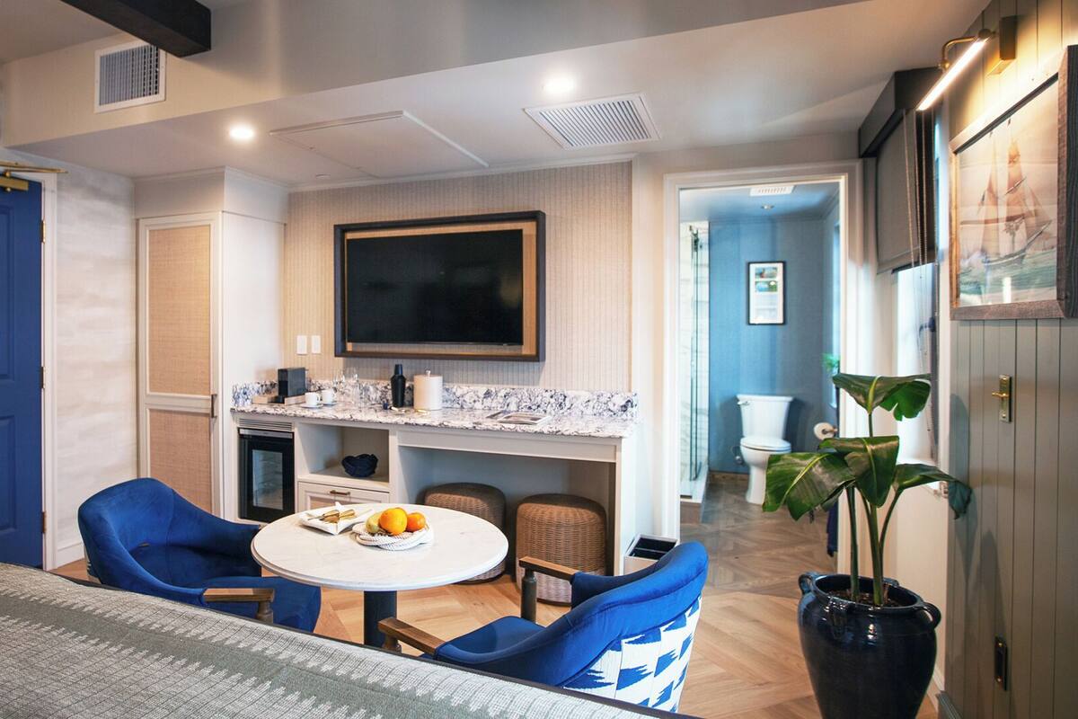 A compact living space with a dining area, kitchenette, and a bathroom.