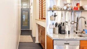 A modern kitchen with wooden cabinets, stainless steel appliances, and a built-in knife rack.