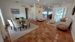 A spacious living area with a dining table, chairs, a sofa, and a coffee table.