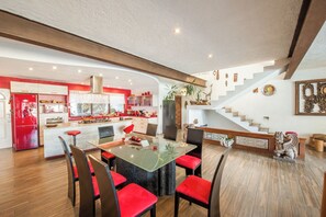 Enjoy a spacious open-plan living space with a kitchen and dining area, featuring a kitchen with a refrigerator and cabinetry, and a dining area with a table and chairs.
