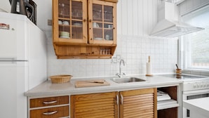 Eine Küche mit weißen Schränken, einer Holzausziehtafel, einer Spüle und einem Herd.