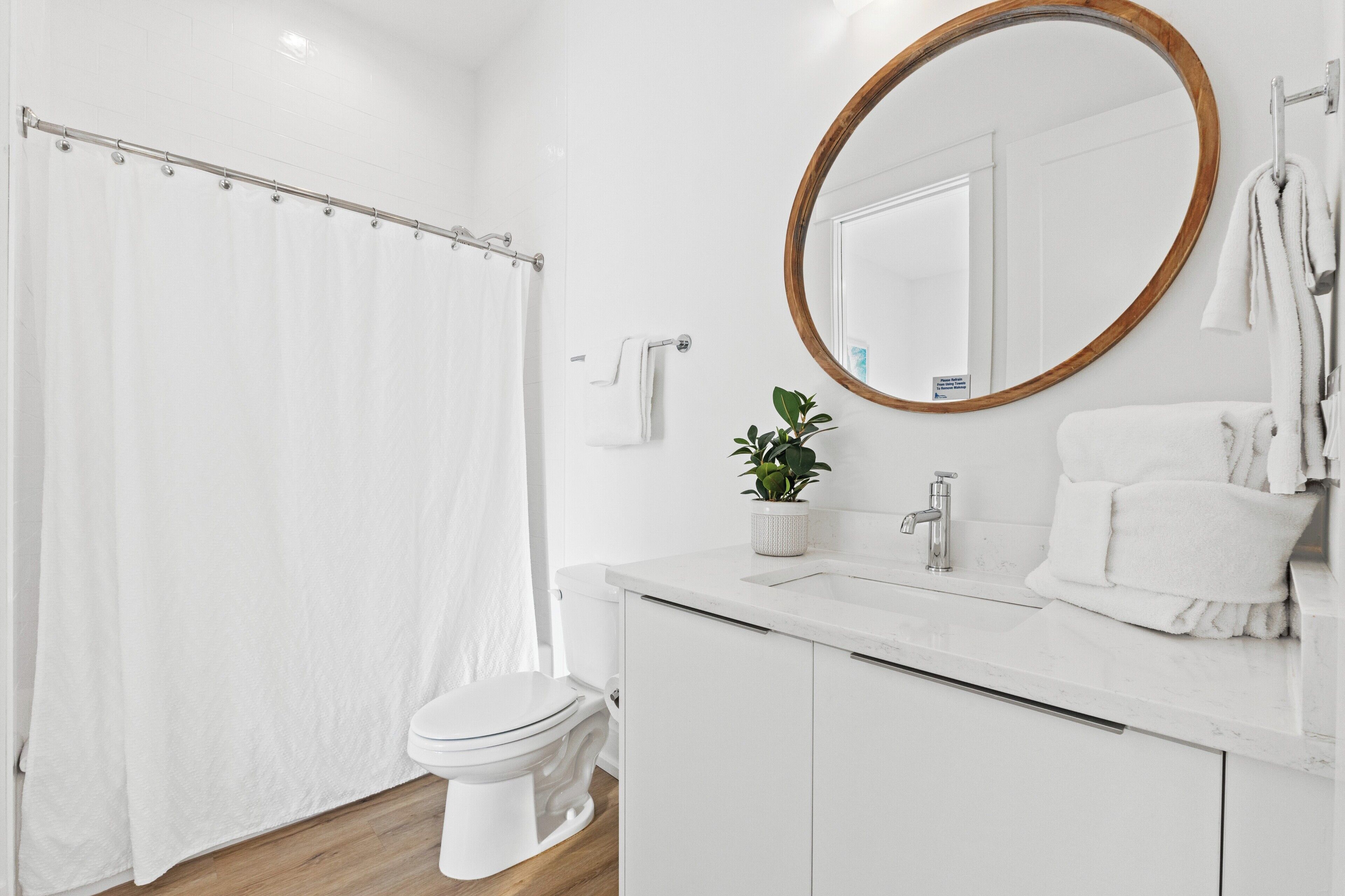 A modern bathroom with a toilet, sink, and shower curtain.