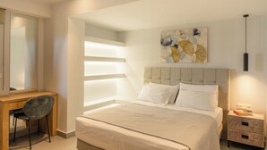 A modern bedroom with a large bed, a desk, and a chair.