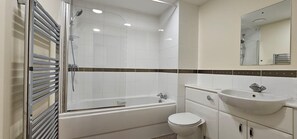A modern bathroom with a glass-enclosed shower, a white bathtub, a sink, and a toilet. - Modern & Lovely 2 Bed in London (London)
