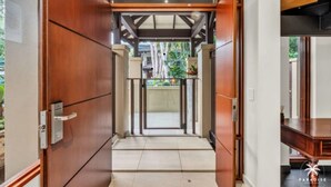 Un corridoio con porte in legno e vista sull'esterno.