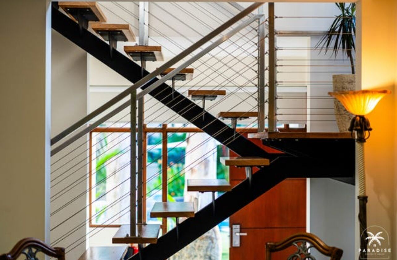 A staircase with a modern design, featuring a combination of metal and wooden elements.