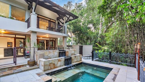Una moderna casa a due piani con piscina, area relax all'aperto e un giardino curato.
