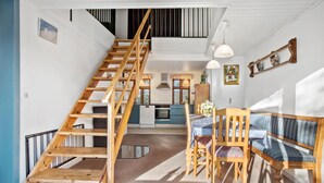 A spacious kitchen with a wooden staircase leading to an upper level.