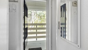 A hallway with a door leading to a balcony with a metal railing. - Lovely apartment in Nexø with WiFi (Nexø)