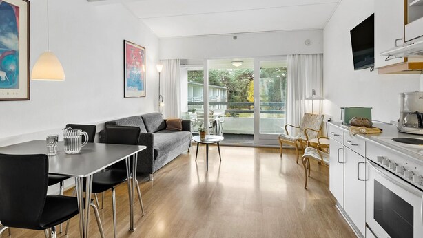 A modern kitchen with a dining area, a sofa, and a view of the outdoors. - Lovely apartment in Nexø with WiFi (Nexø)