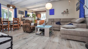 A cozy living room with a sofa, armchairs, and a coffee table. A kitchen is visible in the background. - Amazing home in Besse-sur-Issole (Besse-sur-Issole)