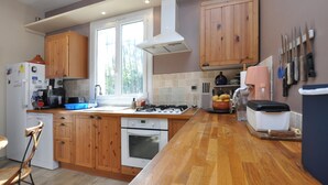 A kitchen with wooden cabinets, a gas stove, an oven, a sink, and a window. - Amazing home in Besse-sur-Issole (Besse-sur-Issole)