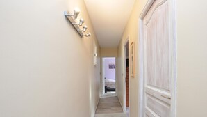A narrow hallway with a light fixture on the left and a door on the right. - Amazing home in Besse-sur-Issole (Besse-sur-Issole)