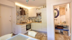 Une cuisine de taille réduite équipée d’une cuisinière à gaz, d’un four à micro-ondes et d’un crédence décorative.